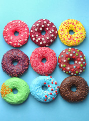 Wall Mural - Delicious colorful donuts on color background