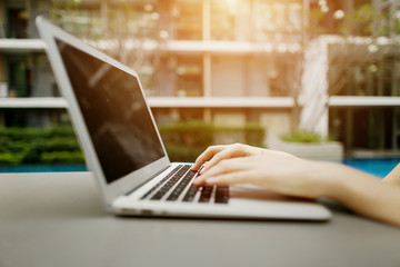 Wall Mural - Close up portrait of woman hands pressing buttons on laptop at sunny day. Fingers typing on the computer keyboard. concept of business freelance working, new technologies