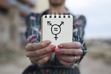 Poster - woman shows notepad with a transgender symbol