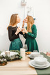 © EdNurg - Couple of girl friends having fun at holiday new year party near festive table