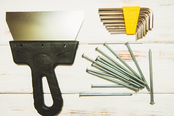 Repair carpenter tools: scraper and wranch on white old wooden background, top view, copy space