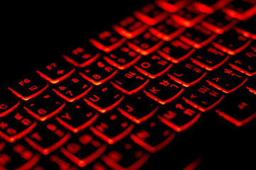 diagonally thai - english language laptop keyboard with glowing red light for hacking ,gaming,progra