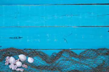 Wall Mural - Blank rustic teal blue wood sign with seashells and fish netting border; wooden background with painted copy space