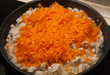 Fried chicken with onions and carrots in a frying pan