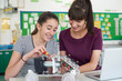 © highwaystarz - Teacher With Female Pupil Studying Robotics In Science Lesson