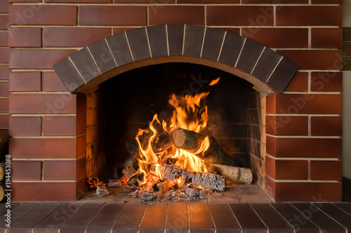Cuadros en Lienzo A brick fireplace in which a fire burns