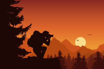 Wall Mural - mountain landscape with forest and tourist photographing flying birds on an orange sky