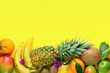 Variety of Different Tropical and Seasonal Summer Fruits. Pineapple Mango Coconut Citrus Oranges Lemons Apples Kiwi Bananas Arranged in Lower Border on Yellow Background.Healthy Lifestyle. Flat Lay