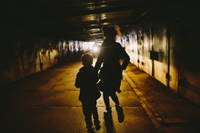 Woman And Kid Running Away Through Tunnel