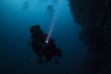 Scuba Diver Diving In The Night With Torch Light