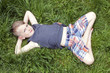 © Carleton Photography/Stocksy - Portrait of a boy lying on grass