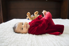 Smiley Baby Girl With Legs Up At With Stuffed Animal
