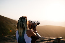 Woman Looking Through A Telescope At The Mountains
