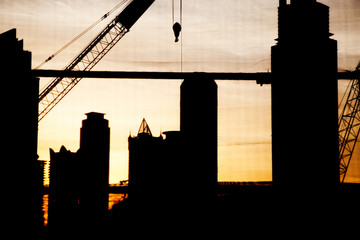 Wall Mural - abstract photo of construction site with crane and skyscrapers in Dubai downtown at sunset - fast growing city concept