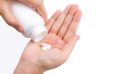 Poster - Adult woman hand pouring tablets pills out of white plastic bottle in to her hand isolated on white background. Health care in adult people