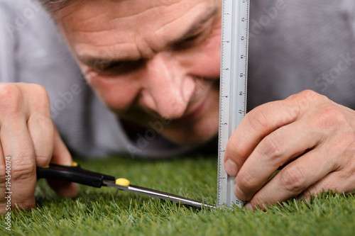 Cuadros en Lienzo Man Using Measuring Scale While Cutting Grass