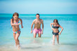 © travnikovstudio - Father and little kids enjoying beach summer tropical vacation
