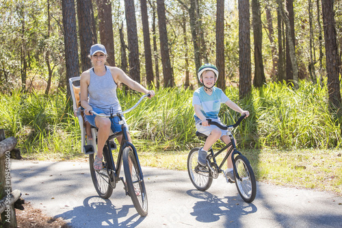 Fotografie, Obraz Family on a bike ride together outdoors on a sunny day
