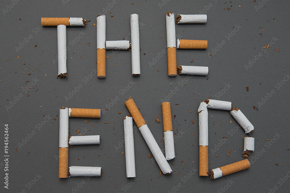 The end of smoking. Cigarettes cause cancer and kill. Gray background.  Stock Photo