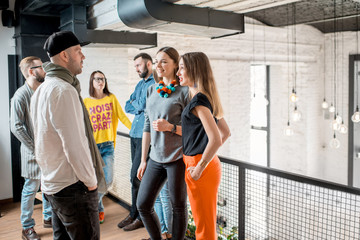 group of friends dressed casually talking together during the coffee break standing in the white con