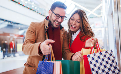 Shopping time. Young couple shopping together in shopping mall. Consumerism, love, dating, lifestyle concept