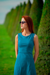 Young redhead girl in sunglasses in Versailles park