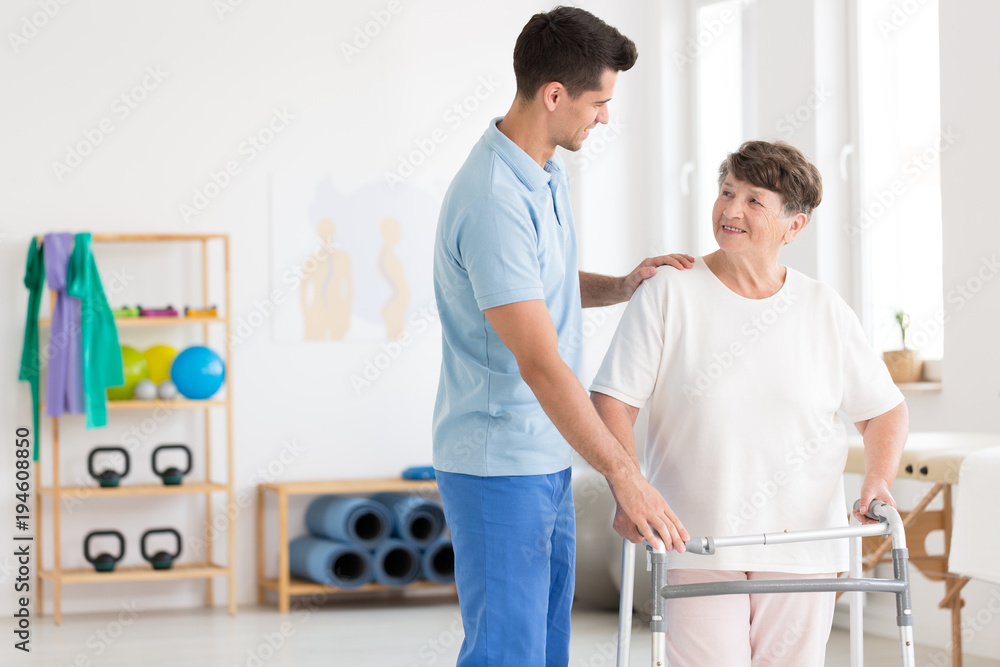 Elderly woman and caring physiotherapist - obrazy, fototapety, plakaty 