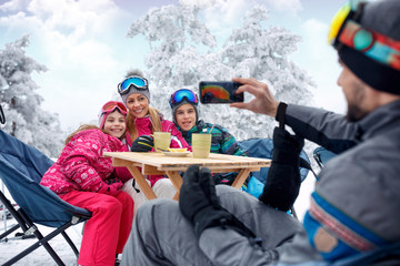 Wall Mural - family enjoying in snow and making selfie