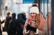 © leszekglasner - Girl using mobile phone in public wifi area at bus stop during cold winter day