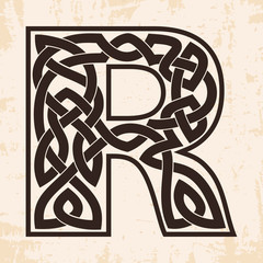 Letter of the English alphabet with Celtic national ornament as interlaced ribbon on a beige background. Paryrus with the aging effect.