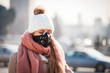 © leszekglasner - Young woman wearing protective mask in the city street, smog and air pollution