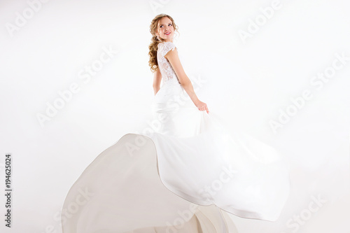 Young Blonde Girl In A White Wedding Dress And Jewelry In