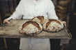 © Maskot - Baker holding bread on tray