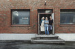 © Maskot - Three people standing in workshop doorway