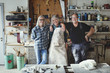 © Maskot - Portrait of cheerful senior coworkers standing against tools at workshop