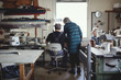 © Maskot - Male and female senior owners discussing while working at workshop