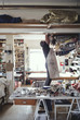 © Maskot - Male owner searching in rolled fabrics at workshop