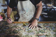 © Maskot - Midsection of owner working on patterned fabric at workbench