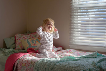 Happy little girl waking up in the morning