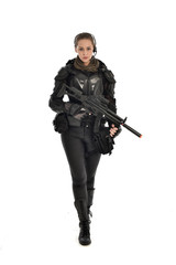 Sticker - full length portrait of female  soldier wearing black  tactical armour, holding a rifle gun, isolated on white studio background.