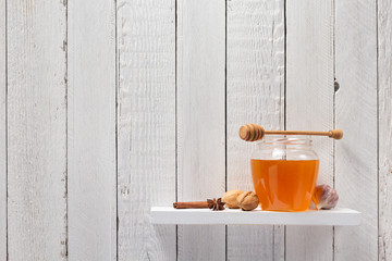 Wall Mural - glass jar of honey on wooden shelf