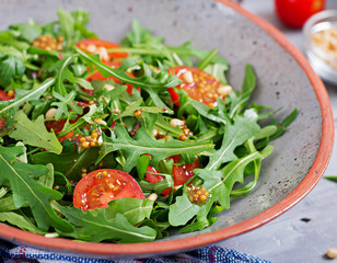 Dietary menu. Vegan cuisine. Healthy salad with arugula, tomatoes and pine nuts.