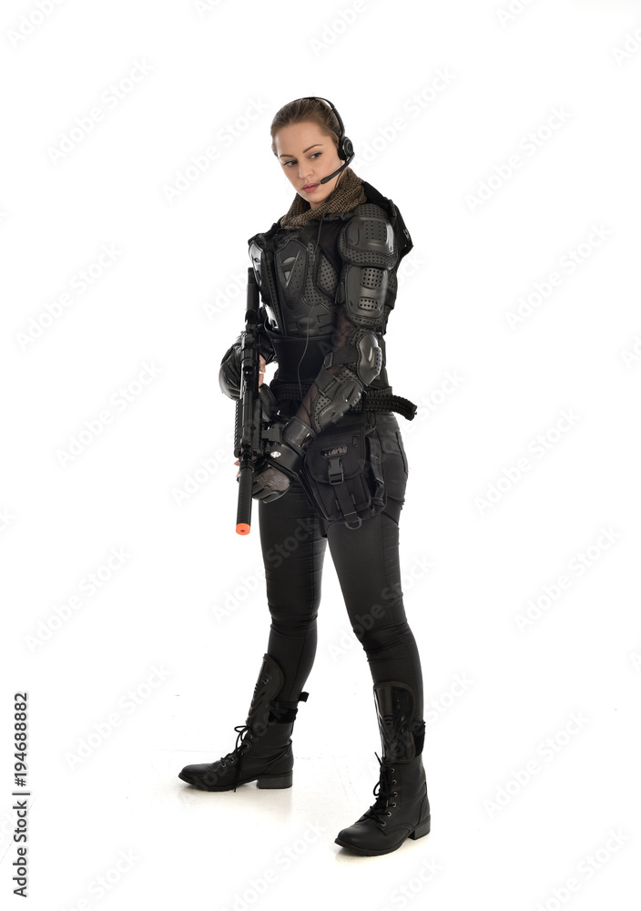 full length portrait of female soldier wearing black tactical armour ...