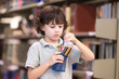© Nattanon - Cute Boy with lot of color pencil in hand while standing in Library.Setup studio shooting.