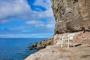 Wall Mural - Plastic Chair with nice view at Seaside / Leisure at rocky beach of Mogan on Grand Canary Island