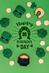 flat lay with festive cookies and happy st patricks day lettering isolated on green