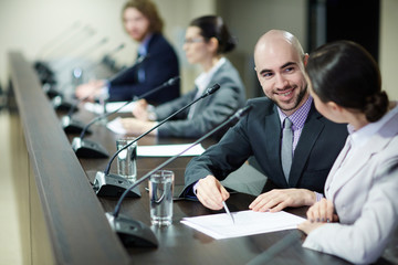 Sticker - Young businessman pointing at contract and offering his neighbour at conference to sign it