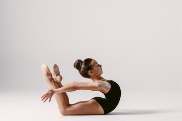 Wall Mural - Young gymnast girl stretching and training