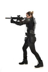 Sticker - full length portrait of female  soldier wearing black  tactical armour, standing  with back to the camera holding a gun, isolated on white studio background.