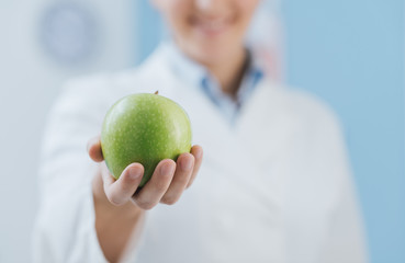 Wall Mural - Professional nutritionist holding a fresh apple